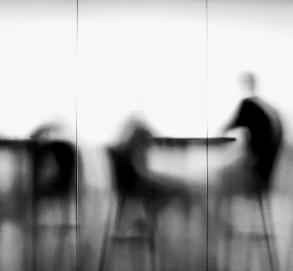 Blurred figures moving through a bright cafe