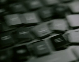 A blurred close-up of laptop keyboard keys, shot at an angle.